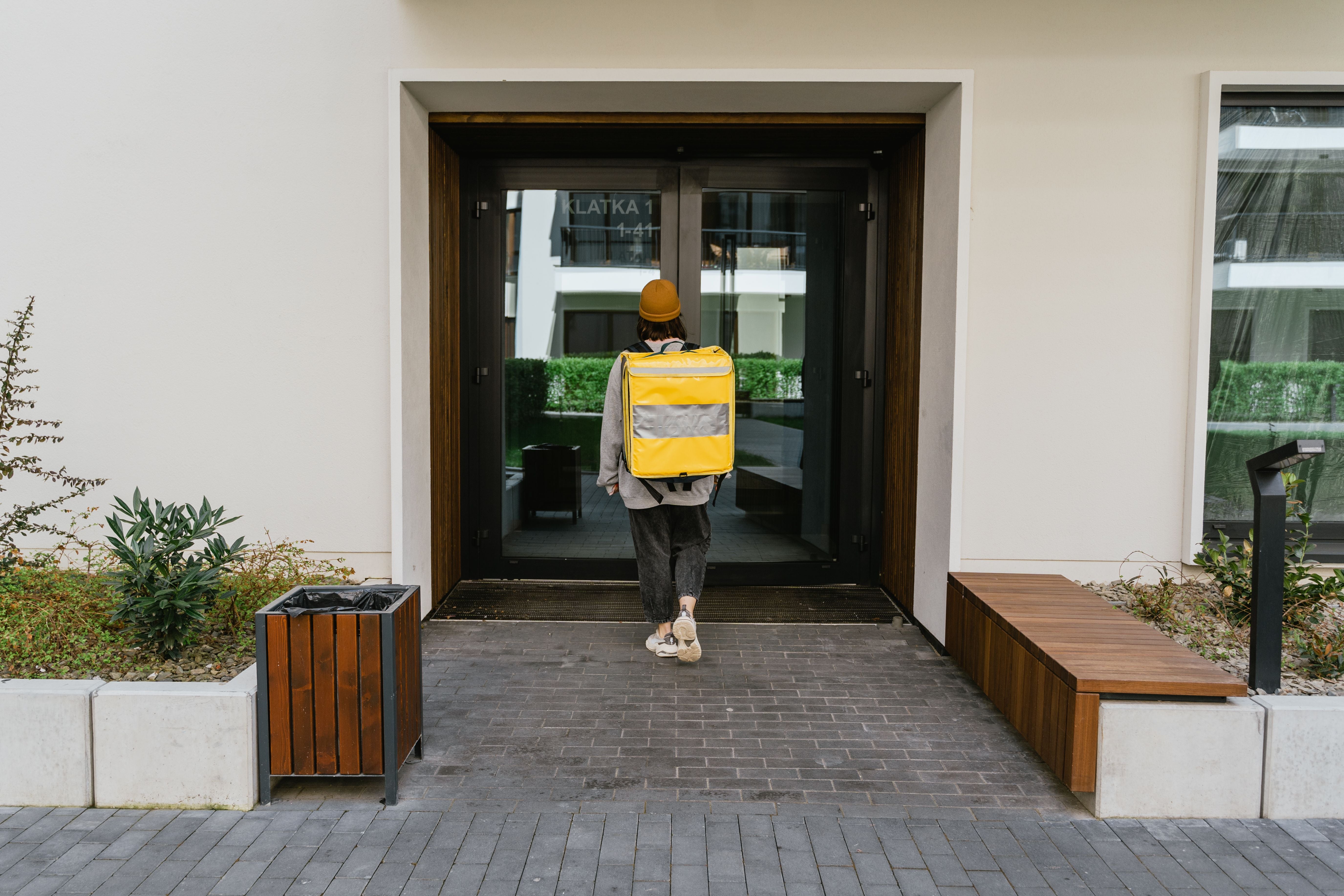 A person arriving at a shared entrance with luggage